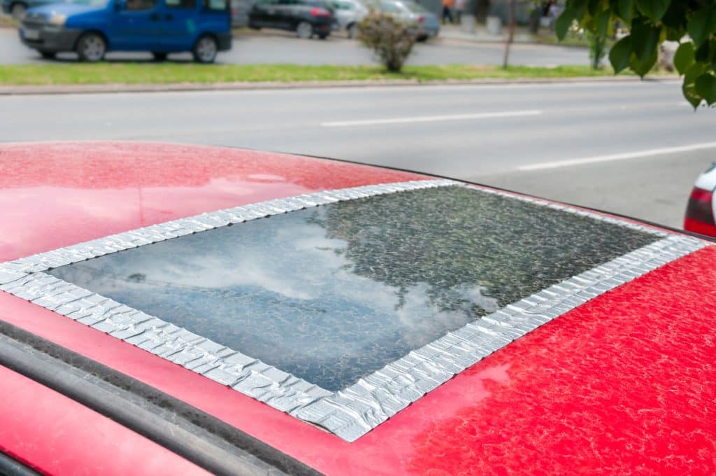 A damaged sunroof on a red car.