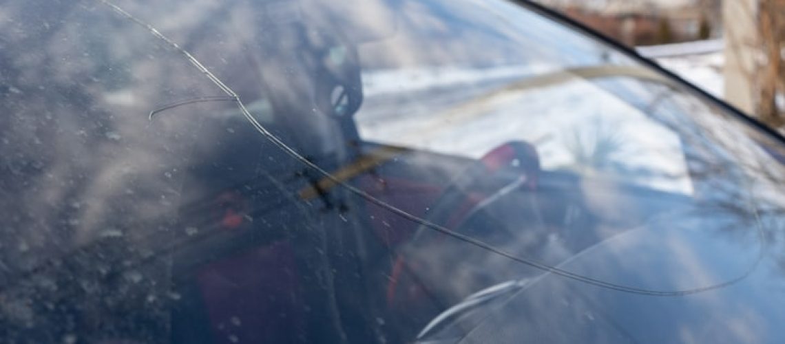 broken windshield with big crack through the glass, damaged car
